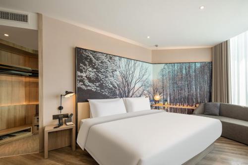 a bedroom with a large white bed and a couch at Atour Hotel Shanghai Minhang Industrial Park in Shanghai