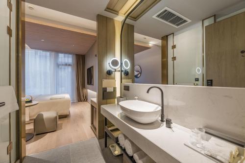 a bathroom with a sink and a large mirror at Atour Hotel Shanghai World Expo Center in Shanghai