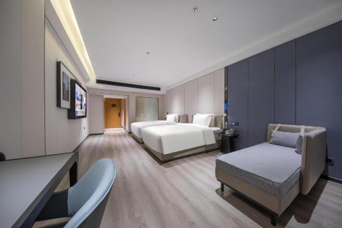 duży pokój hotelowy z 2 łóżkami i kanapą w obiekcie Atour X Hotel Guangzhou Baiyun International Airport Renhe Station w Guangzhou