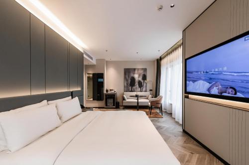 寧波的住宿－宁波舟宿夜江亚朵S酒店，卧室配有白色的床和大屏幕电视