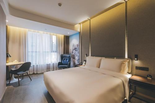 a hotel room with a large bed and a desk at Atour Hotel Lanzhou Dongfanghong Plaza in Lanzhou