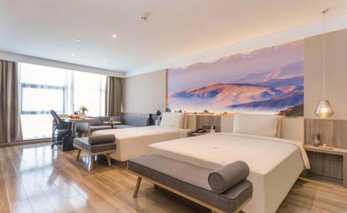 西寧市にあるAtour Hotel Xining East Kunlun Roadのベッド2台とテーブルが備わるホテルルームです。