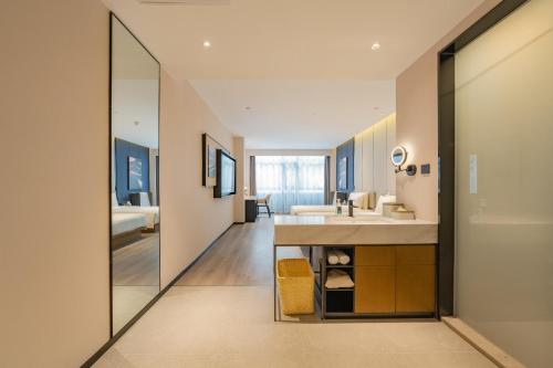 uma casa de banho com um lavatório e um espelho grande em Atour Hotel Beijing Guomao Tuanjie Lake em Pequim