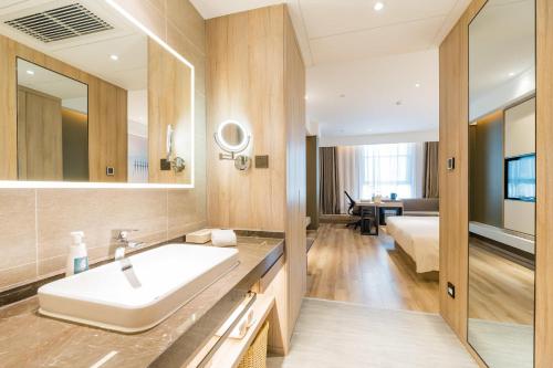 a bathroom with a sink and a large mirror at Atour Hotel Ningbo International Convention and Exhibition Center in Ningbo