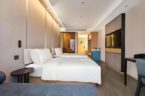 a hotel room with two beds and a television at Atour Hotel Kunming Changshui International Airport in Kunming