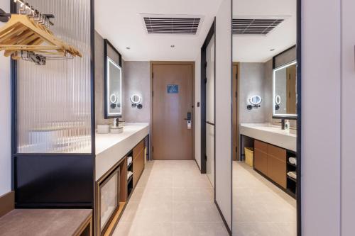ein Badezimmer mit zwei Waschbecken und zwei Spiegeln in der Unterkunft Atour Hotel Beijing South Xizhan Road in Peking