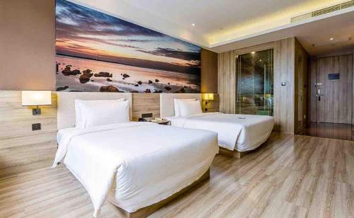 a bedroom with two beds and a painting on the wall at Atour Hotel Shanghai Pudong Zhangjiang Park in Shanghai