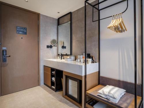 a bathroom with a sink and a mirror at Atour Hotel Xiamen North Station Jiageng Stadium in Xiamen