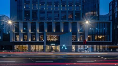 a building on a city street at night at A T HOUSE Shanghai City Center Xujiahui - Free Night Snacks from 930pm-11pm in Shanghai