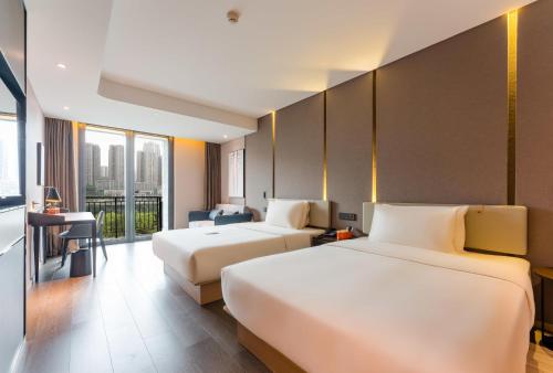 a hotel room with two beds and a desk at Atour Hotel Chongqing Tiandi NetEase Cloud Music in Chongqing