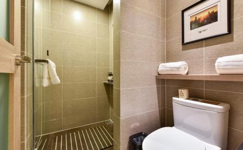 a bathroom with a toilet and a glass shower at Atour Hotel Tianjin Binhai 1st Street in Binhai