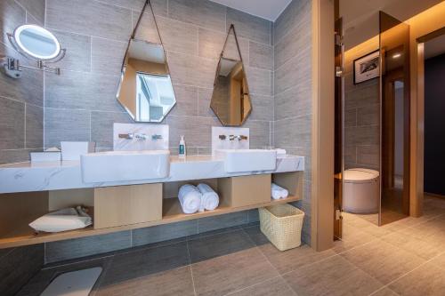 a bathroom with two sinks and a mirror at Atour Hotel Shenzhen Fuhai International Convention and Exhibition Center in Bao'an