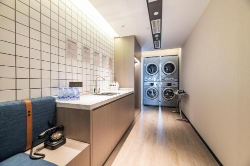 a laundry room with a washer and dryer at Atour X Hotel Chengdu Shuangnan Wuhou Avenue Station in Chengdu