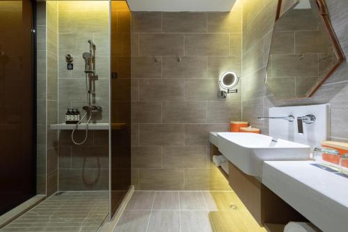 a bathroom with a sink and a shower at Atour Hotel Wuhan Tiandi Hankou Jiangtan in Wuhan