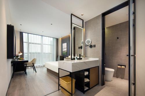 a bathroom with a sink and a large mirror at Atour Hotel Nantong North Street Vientiane City in Nantong