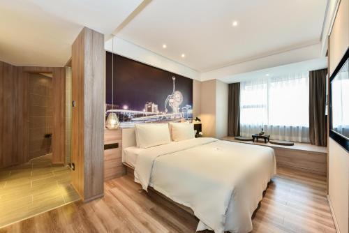 a hotel room with a bed and a television at Atour Hotel Tianjin Binhai 1st Street in Binhai