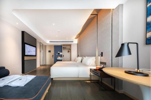 a hotel room with a bed and a desk at Atour Hotel Zhuhai Tangjiawan University Jinding Plaza in Zhuhai