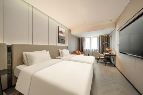a hotel room with two beds and a flat screen tv at Atour Hotel Shanghai Wujiaochang West Yingao Road Station in Shanghai