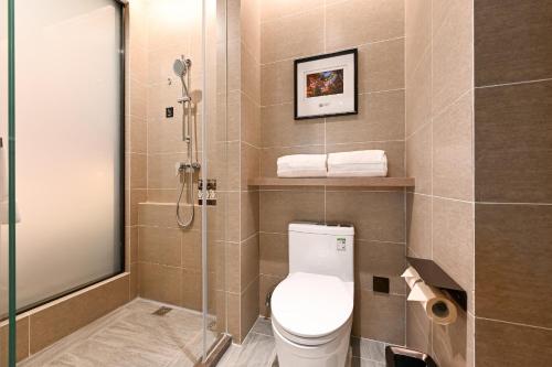 a bathroom with a toilet and a glass shower at Atour Hotel Shenyang South Station Quanyun Road in Shenyang