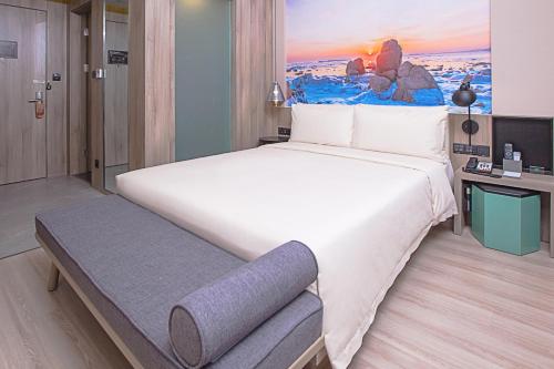 um quarto com uma grande cama branca e uma secretária em Atour Hotel Qinhuangdao Railway Station Yingbin Road em Qinhuangdao