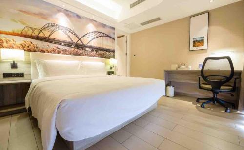 a bedroom with a large bed and a desk and a chair at Atour Hotel Qinhuangdao Xiangxi Sea in Qinhuangdao