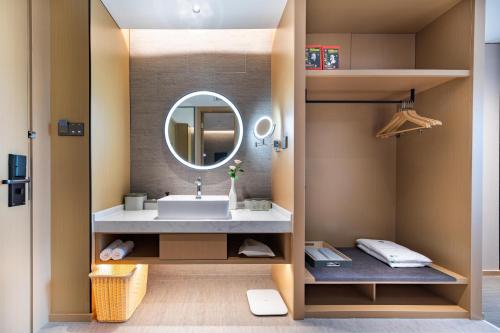 uma casa de banho com um lavatório e um espelho em Atour Hotel Shenzhen Futian Xiangmi Lake em Shenzhen