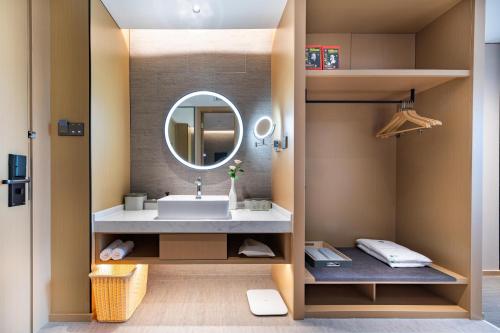un baño con lavabo y espejo en Atour Hotel Shenzhen Futian Xiangmi Lake, en Shenzhen