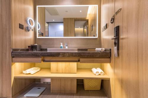 een badkamer met een wastafel en een spiegel bij Atour Hotel Jinan Zhangqiu Century Avenue in Jinan