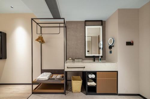 Atour Hotel Hangzhou Xintiandi Zhongda Intime في هانغتشو: حمام مع حوض ومرآة