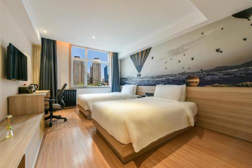 a hotel room with two beds and a desk at Atour Light Hotel Beijing Jianguomen CBD in Beijing