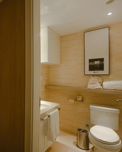 a bathroom with a white toilet and a sink at Atour Hotel Qinhuangdao Xiangxi Sea in Qinhuangdao