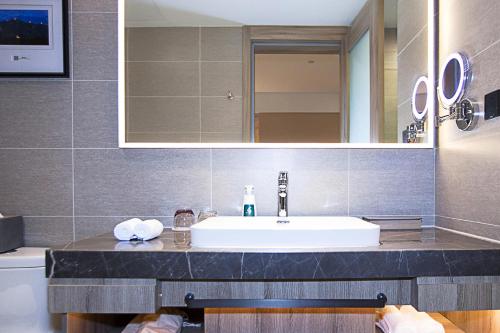 a bathroom with a sink and a mirror at Atour Hotel Qinhuangdao Railway Station Yingbin Road in Qinhuangdao