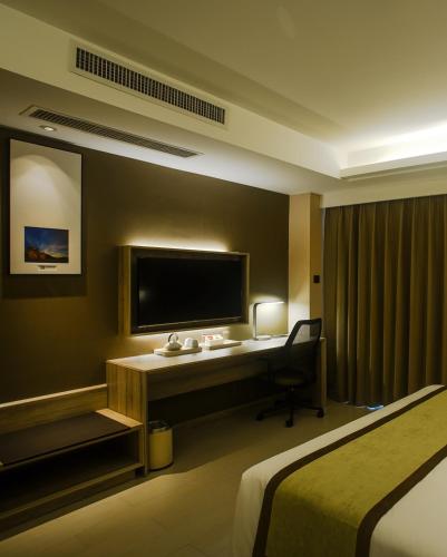 a hotel room with a desk and a television at Atour Hotel Qinhuangdao Xiangxi Sea in Qinhuangdao