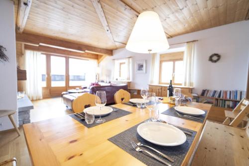 a dining room with a table with plates and wine glasses at Chasa Rontsch Madlaina in Scuol