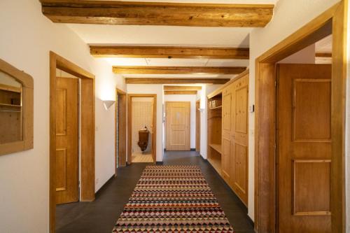 a hallway with wooden doors and a rug on the floor at Chasa Rontsch Madlaina in Scuol