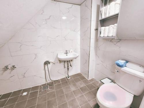 ソウルにあるRaumの白いバスルーム(トイレ、シンク付)