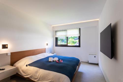 - une chambre avec un lit, 2 serviettes et une télévision à écran plat dans l'établissement Agrianthe Palmiers AP4380 By Riviera Holiday Homes, à Villefranche-sur-Mer