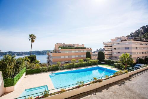 une image d'une piscine en face des bâtiments dans l'établissement Agrianthe Palmiers AP4380 By Riviera Holiday Homes, à Villefranche-sur-Mer