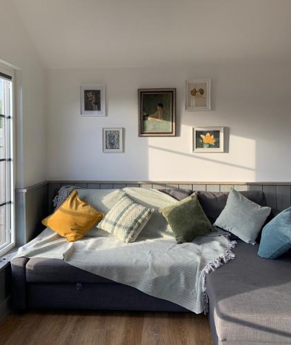a couch with pillows on it in a living room at Cosy Cabins without hot tub - Greenway Farm, Drybrook, Forest of Dean in Drybrook