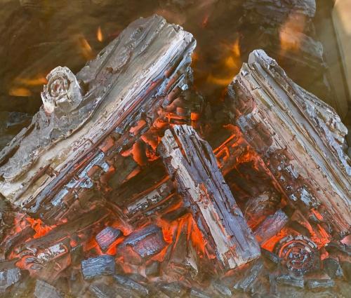 une pile de bois au-dessus d'un feu dans l'établissement Holiday Lodges with hot tub & Cosy Cabins - Greenway Farm, Drybrook, Forest of Dean, à Drybrook