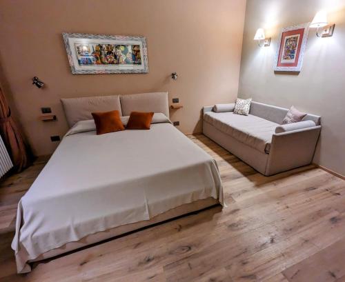 a bedroom with a large bed and a couch at Agriturismo Peq Agri-Resort Tovo in Tovo San Giacomo