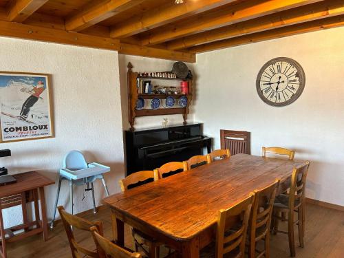 a dining room with a wooden table and a clock on the wall at Les Trembles MOUNTAIN & QUIET chalet 12 pers in Veysonnaz