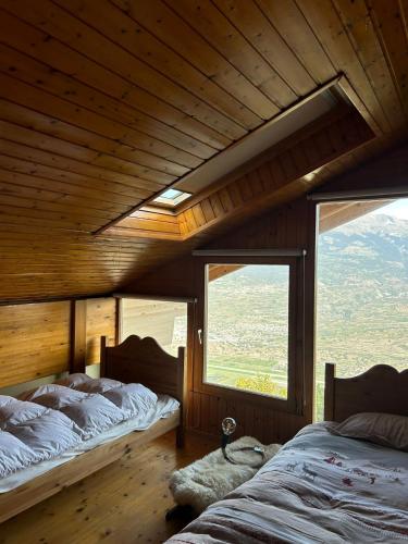 two beds in a room with two windows at Les Trembles MOUNTAIN & QUIET chalet 12 pers in Veysonnaz
