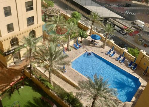 widok na basen z palmami w obiekcie Marina Homes w Dubaju