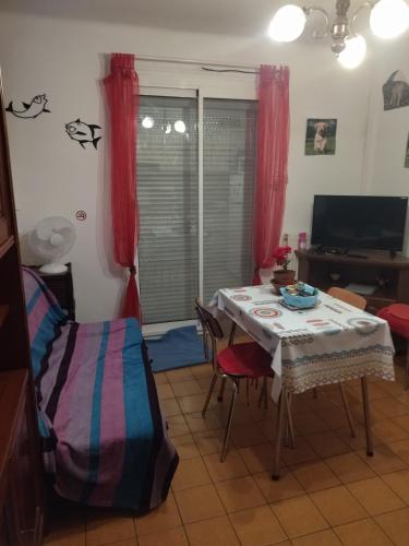 - un salon avec une table et un lit dans l'établissement F1 chambre et cuisine, à Reynès