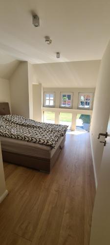 a bedroom with a bed and a wooden floor at Pferdeparadies Untergrünhagen in Bad Fallingbostel