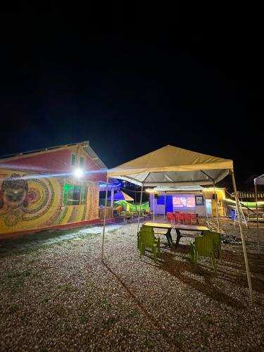 a picnic table in front of a building at night at Crown Bliss - Riverside Luxury Paradise in Kasol