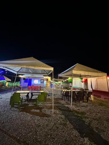 a group of picnic tables under tents at night at Crown Bliss - Riverside Luxury Paradise in Kasol