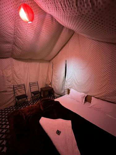 a room with a bed in a tent with two chairs at Crown Bliss - Riverside Luxury Paradise in Kasol