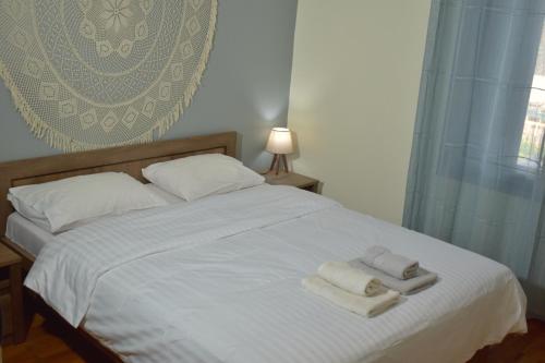 1 dormitorio con 1 cama con 2 toallas en Rose's House, en Tríkala